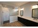 Modern bathroom showcasing dual sinks, black cabinets, and luxurious walk-in shower with marble tile at 32513 N 135Th Dr, Peoria, AZ 85383