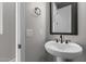 Bathroom featuring pedestal sink, modern fixtures, and framed mirror with vanity lighting at 32513 N 135Th Dr, Peoria, AZ 85383