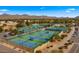This striking aerial view showcases multiple tennis courts against the picturesque backdrop of scenic mountains at 10338 E San Salvador Dr, Scottsdale, AZ 85258
