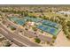 A beautiful aerial view features tennis courts, parking, and nearby baseball fields with a backdrop of homes and a lake at 10338 E San Salvador Dr, Scottsdale, AZ 85258