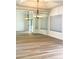 Dining area showcasing wood-look floors, mirrored wall, chandelier, and large window at 19400 N Westbrook Pkwy # 311, Peoria, AZ 85382