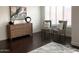 Bedroom view featuring dark wood floors, modern dresser, abstract art and two accent chairs near a window at 3076 E La Costa Dr, Gilbert, AZ 85298