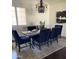 Dining room with dark wood floors and dark upholstered chairs set around a rectangular table beneath a chandelier at 3076 E La Costa Dr, Gilbert, AZ 85298