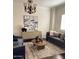 Comfortable living room with decorative chandelier, eye-catching artwork and stylish furniture on a patterned area rug at 3076 E La Costa Dr, Gilbert, AZ 85298