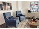 Inviting living room featuring two stylish armchairs with elegant artwork, neutral toned area rug, and modern furniture at 3076 E La Costa Dr, Gilbert, AZ 85298