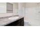 Bright bathroom featuring a single sink with granite-style countertops and a shower-tub combo at 38120 W Excussare Way, Maricopa, AZ 85138