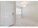 Bright entryway features neutral paint, tile flooring, and a modern chandelier in the adjacent room at 38120 W Excussare Way, Maricopa, AZ 85138