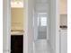 Hallway with tile flooring and views of the bathroom, laundry area, and carpeted bedroom at 38120 W Excussare Way, Maricopa, AZ 85138