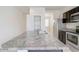 Kitchen island featuring granite countertops, stainless steel appliances, and dark wood cabinets at 38120 W Excussare Way, Maricopa, AZ 85138