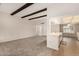 Bright open-concept living room featuring beam ceiling detail and access to kitchen at 9518 W Hidden Valley Cir, Sun City, AZ 85351