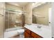 This is a bathroom with a vanity sink and shower and bathtub with shower door at 2606 N 159Th Dr, Goodyear, AZ 85395