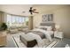 Staged primary bedroom with bay window, ceiling fan, and neutral decor at 2606 N 159Th Dr, Goodyear, AZ 85395