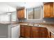 Kitchen showcasing wood cabinets, a stainless sink, and views into the adjacent dining and living areas at 4925 E Desert Cove Ave # 350, Scottsdale, AZ 85254