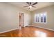 Inviting bedroom space with light-colored walls, warm wood floors, a ceiling fan, and a large window at 1346 W Willetta St, Phoenix, AZ 85007