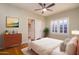 Relaxing bedroom features light-colored walls, wood floors, a ceiling fan, and a door leading to the hallway at 1346 W Willetta St, Phoenix, AZ 85007