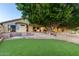 Expansive backyard with artificial grass, brick accents, and mature trees providing shade and privacy at 2107 S Paseo Loma --, Mesa, AZ 85202