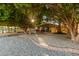 Serene backyard setting with mature trees, gravel landscaping, and a covered patio for outdoor relaxation and entertainment at 2107 S Paseo Loma --, Mesa, AZ 85202