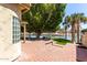 Waterfront backyard features brick patio, green turf, mature trees, and lake views at 2107 S Paseo Loma --, Mesa, AZ 85202