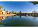 Scenic lake view featuring lush landscaping, mature trees, and clear reflections in the water at 2107 S Paseo Loma --, Mesa, AZ 85202