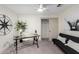 Home office with a black futon, glass desk, ceiling fan, and access to a closet at 2107 S Paseo Loma --, Mesa, AZ 85202