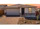 Charming single-story home featuring a brick driveway, attached garage, and inviting entrance at 16923 W Siesta Way, Goodyear, AZ 85338