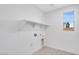 Laundry room featuring white walls, light-colored wood flooring, and utility sink at 16923 W Siesta Way, Goodyear, AZ 85338