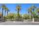 Attractive community entrance with stone sign and lush landscaping featuring palm trees and green lawns at 27789 N 129Th Ln, Peoria, AZ 85383