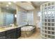 Spa-like bathroom featuring a large soaking tub and glass block accents at 27264 N 103Rd Way, Scottsdale, AZ 85262