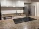 Updated kitchen featuring granite countertops, stainless steel refrigerator, and a cooktop at 4232 W Citrus Way, Phoenix, AZ 85019