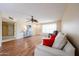 Bright living room featuring wood floors, a ceiling fan, and a comfortable seating area with large windows at 10501 W Willow Creek Cir, Sun City, AZ 85373