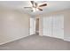 Well-lit bedroom featuring ceiling fan and double door closet at 916 E Beautiful Ln, Phoenix, AZ 85042