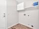 Bright laundry room with white cabinets and wood-look floors at 916 E Beautiful Ln, Phoenix, AZ 85042