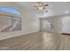 Bright living room with laminate flooring, a ceiling fan, and a door at 916 E Beautiful Ln, Phoenix, AZ 85042
