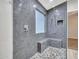 Large walk-in shower with gray tile and built-in seat at 916 E Beautiful Ln, Phoenix, AZ 85042