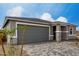 Charming home featuring a gray garage door, stone accents, and a beautiful paved driveway at 18605 E Panchito Dr, Gold Canyon, AZ 85118