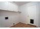 Bright laundry room featuring white cabinets, a utility sink hookup, and a convenient pet door at 1416 E Sapium Way, Phoenix, AZ 85048