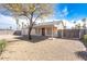 Large gravel backyard showcasing the property's rear facade, covered patio, and secure fencing at 8464 W Royal Blackheath Dr, Arizona City, AZ 85123