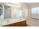 Bright bathroom featuring a double sink vanity, large mirror, and accessible tub with safety grab bars at 8464 W Royal Blackheath Dr, Arizona City, AZ 85123