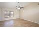 Neutral bedroom with tile floors, ceiling fan, and a large window for natural light at 8464 W Royal Blackheath Dr, Arizona City, AZ 85123