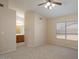 Spacious bedroom with carpet, ceiling fan, and access to the bathroom vanity at 8464 W Royal Blackheath Dr, Arizona City, AZ 85123