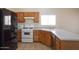 Kitchen features wood cabinets, white appliances, and bright lighting at 8464 W Royal Blackheath Dr, Arizona City, AZ 85123