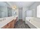 Well-lit bathroom with dual sinks, a large mirror, and separate shower and tub at 32030 N 20Th Ln, Phoenix, AZ 85085