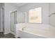 Bright bathroom featuring a separate shower, soaking tub, and a large window for natural light at 32030 N 20Th Ln, Phoenix, AZ 85085