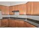 Spacious kitchen with wooden cabinets, black countertops, and modern appliances at 32030 N 20Th Ln, Phoenix, AZ 85085