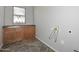 A well-lit laundry room features a sink, wooden cabinets, and tile flooring at 32030 N 20Th Ln, Phoenix, AZ 85085