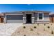 Inviting home with a gray garage door, stone accents, and a paved driveway leading to the front entrance at 18714 E Panchito Dr, Gold Canyon, AZ 85118