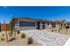 Charming home showcasing a gray garage door, paved driveway, and low-maintenance desert landscaping at 18714 E Panchito Dr, Gold Canyon, AZ 85118