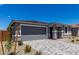 Home with a gray garage door, stone accents, a paved driveway, and desert landscaping at 18714 E Panchito Dr, Gold Canyon, AZ 85118