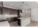 Well-lit kitchen boasts dark wood cabinets, stainless appliances, island and subway tile backsplash at 18714 E Panchito Dr, Gold Canyon, AZ 85118