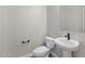 Compact bathroom with a toilet, a pedestal sink, and a framed mirror above the sink at 1021 W Ridge Rd, Apache Junction, AZ 85120
